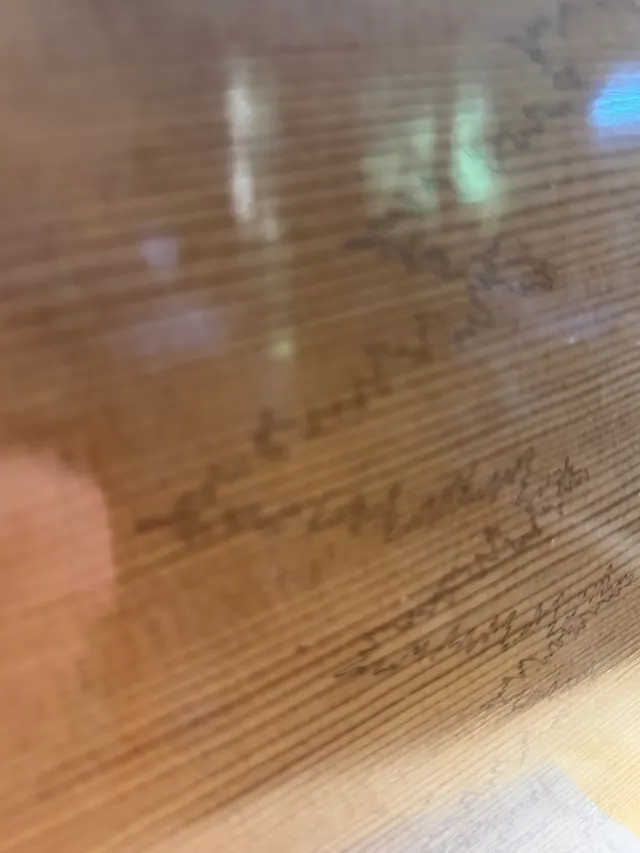 Signatures written on the inside of a spruce top before the box is closed