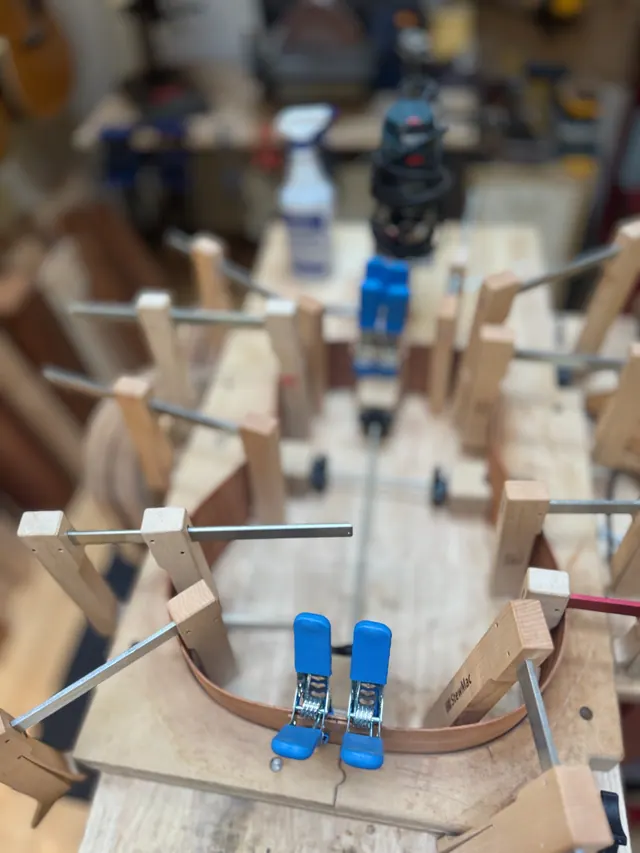 Blue clamps closing the joint at the tail of a rim in the workboard
