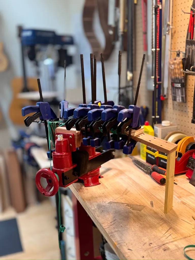 Kerfing clamped — a forest of blue Irwin clamps press the linings into the rim