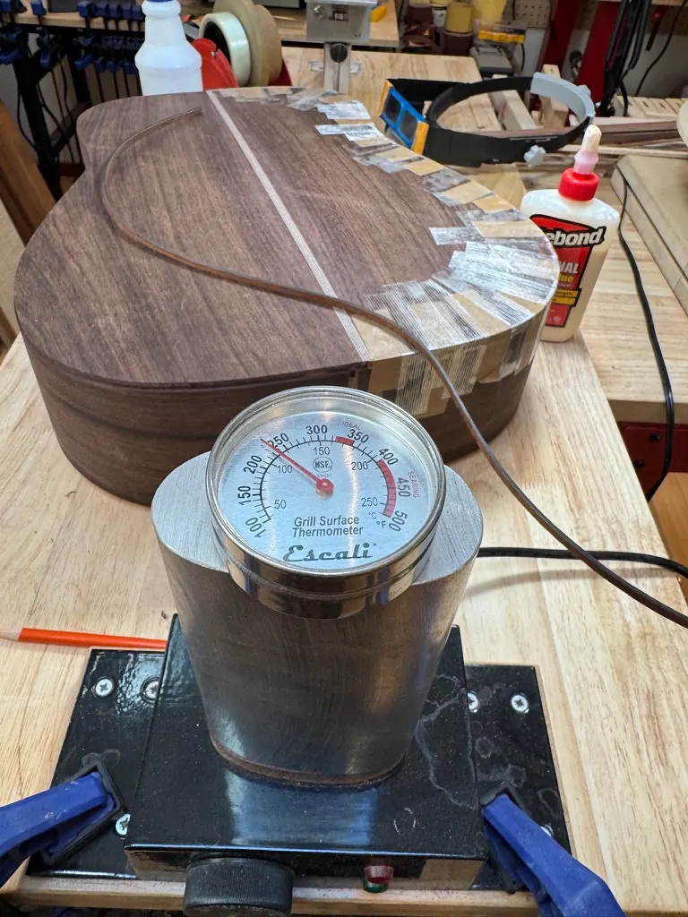 Bending Honduran mahogany sides on the hot pipe, grill thermometer reading temperature