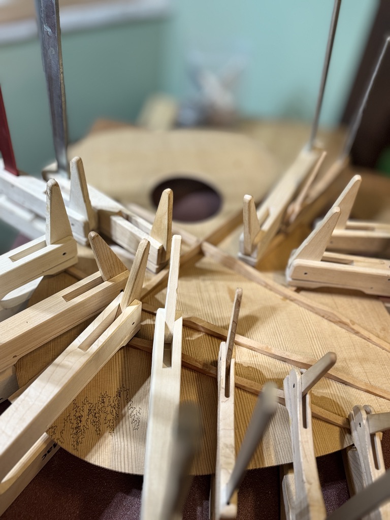 Go-bar deck holding braces to a spruce top, soundhole visible below