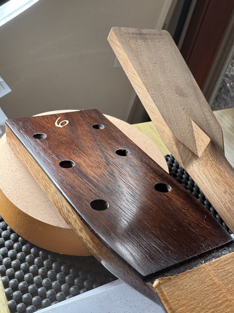Slotted rosewood headstock plate branded with the number 6